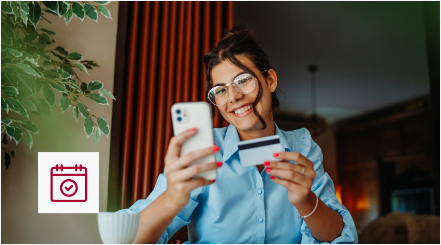 A woman takes a picture of her credit card with her smartphone, ensuring the card information is visible.