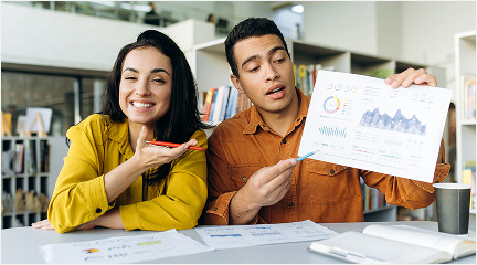 A couple of people analyzing a chart together, discussing data and insights.